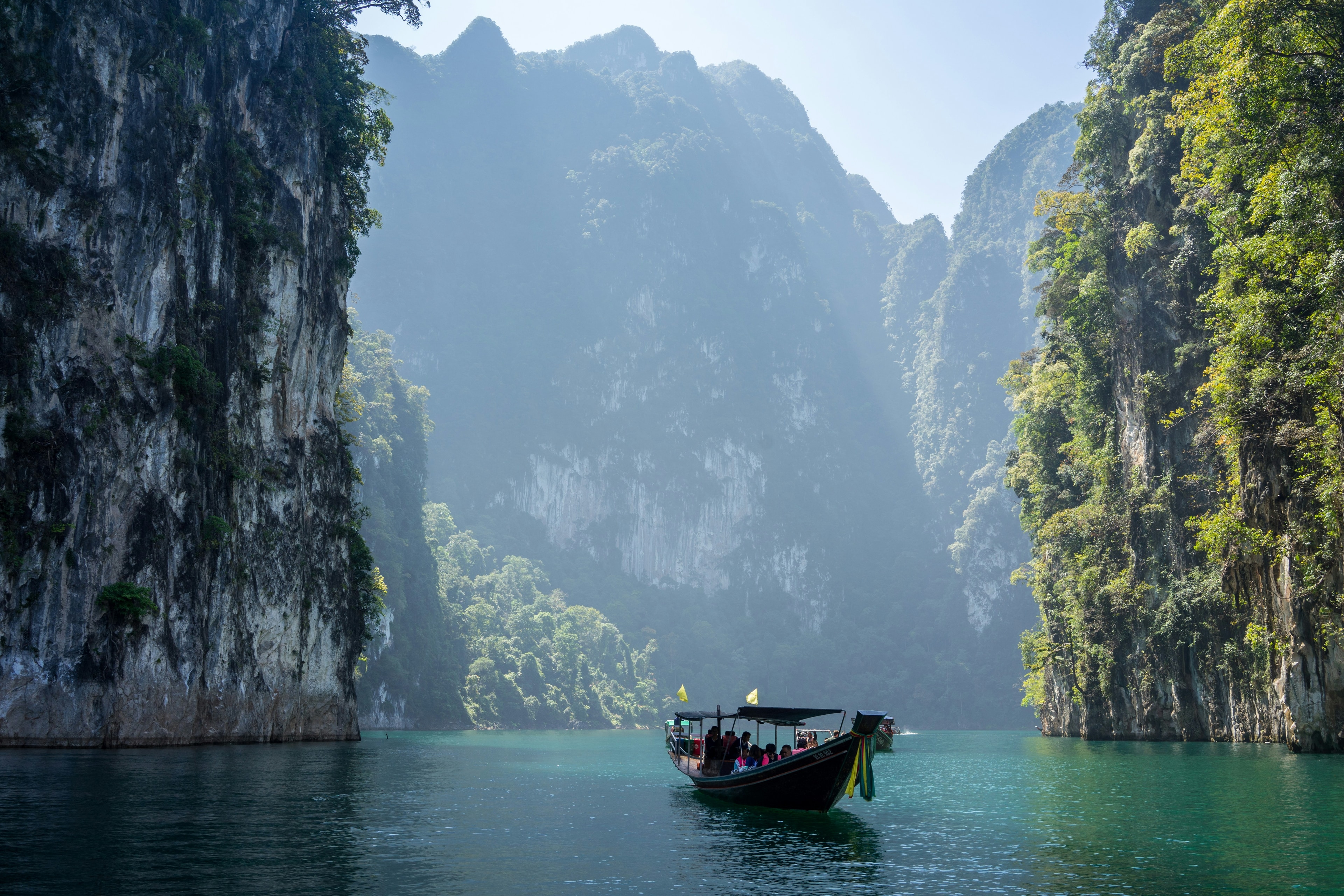 Boat moving through Thailand lagoon cliffs